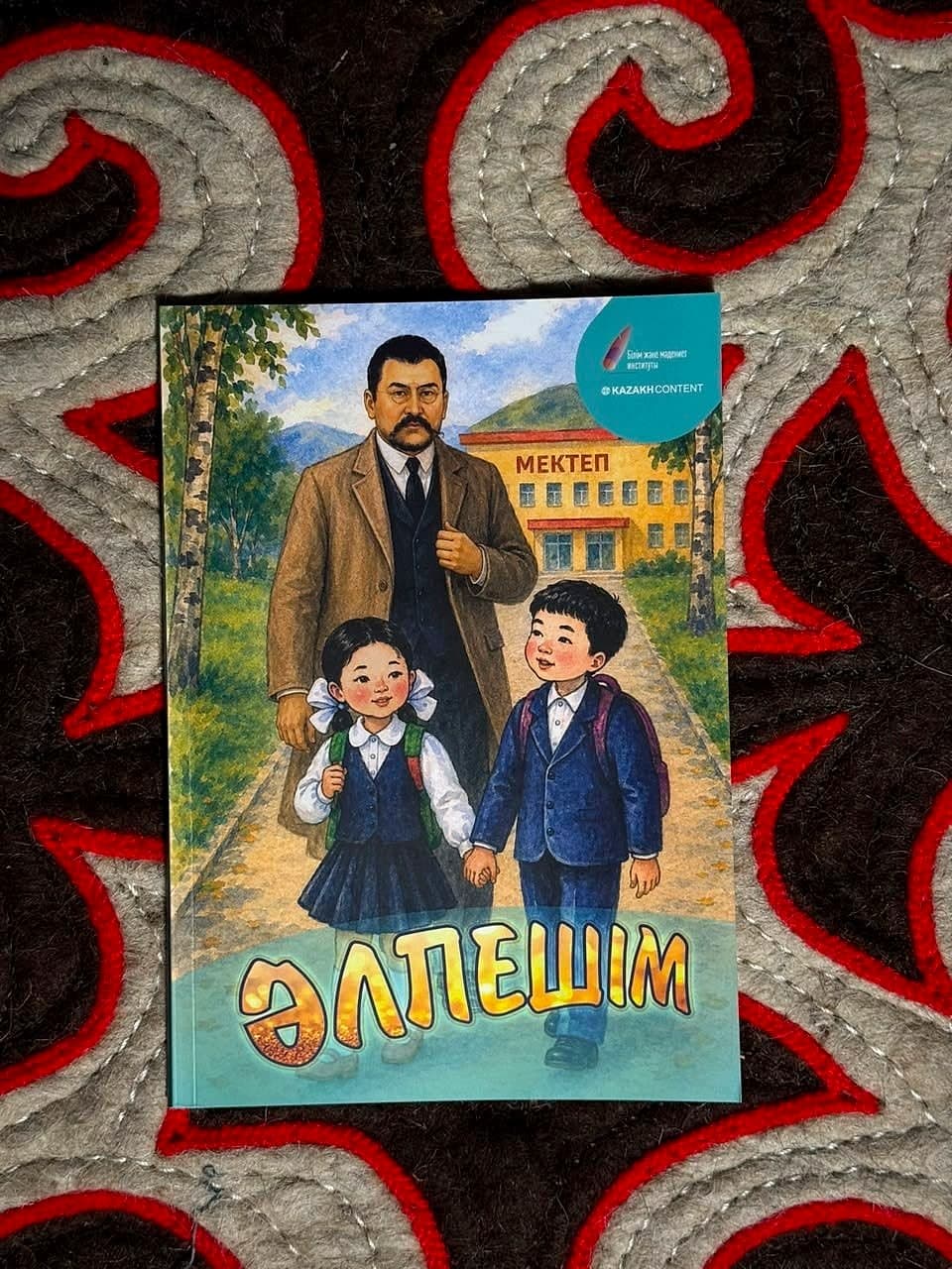 «Әлпешім» әліппесі текеметтің үстінде