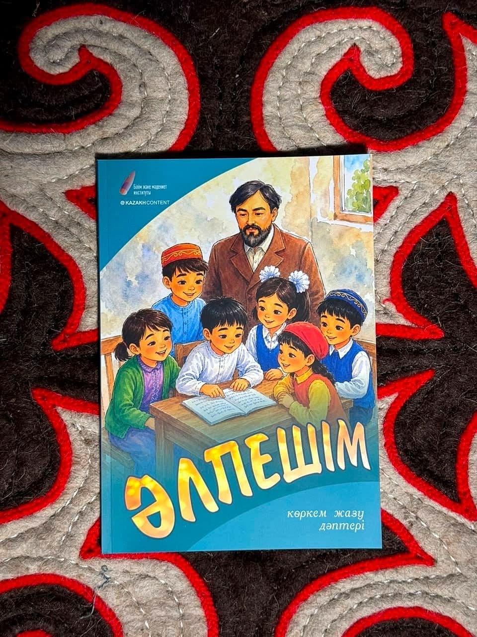«Әлпешім» көркем жазу дәптері текеметтің үстінде